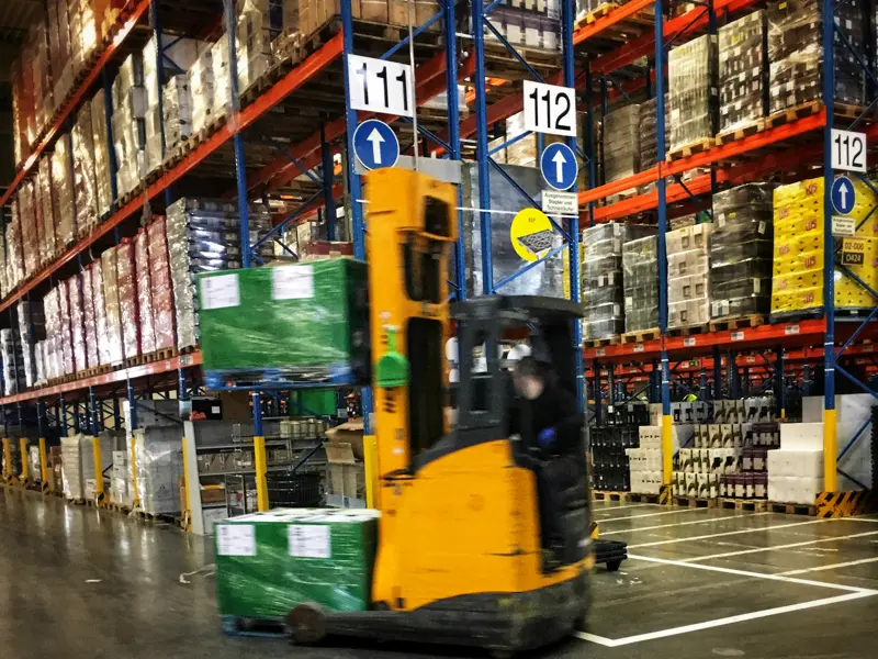 Electric reach truck working in a racked warehouse, industrial battery supply Essex